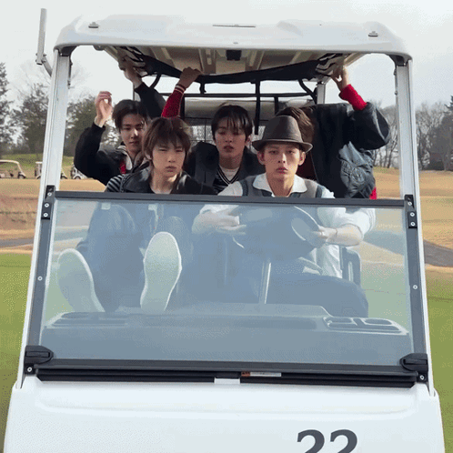 A Group Of Young Men Are Sitting In A Golf Cart With The Number 22 On It GIF