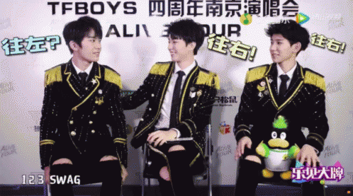 A Group Of Young Men Are Sitting In Front Of A Sign That Says Tfboys On It GIF