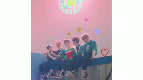 a group of young men are sitting on a wall in front of a disco ball .