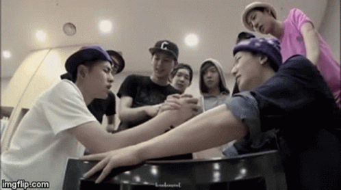 Young Men Holding Hands Around Table GIF