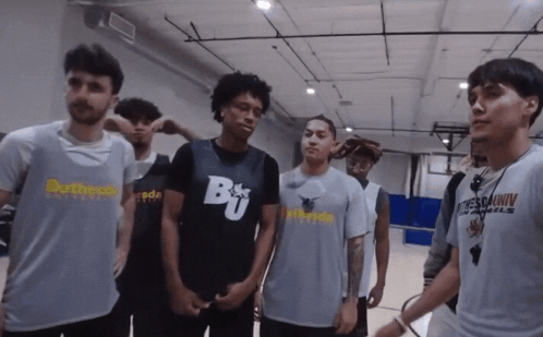 A Group Of Young Men Are Standing In A Gym With One Wearing A Shirt That Says Brother GIF