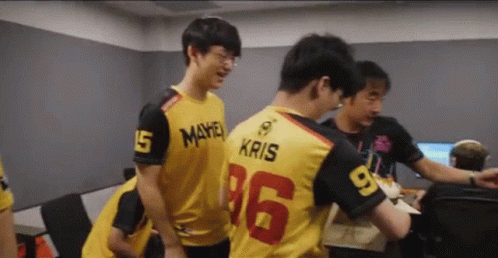 a group of young men are standing in a room and one of them is wearing a jersey with the number 16 on it .