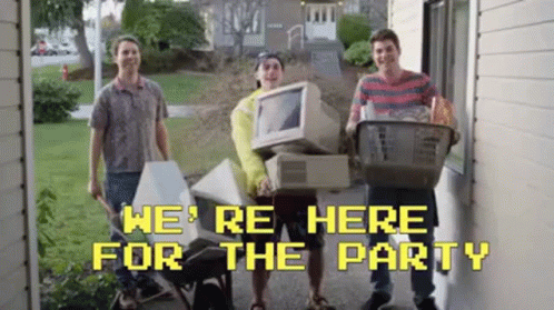 A Group Of Young Men Are Standing In Front Of A House Holding A Computer And A Basket Of Groceries . GIF