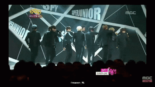 A Group Of Young Men Are Standing In Front Of A Sign That Says Superjunior GIF