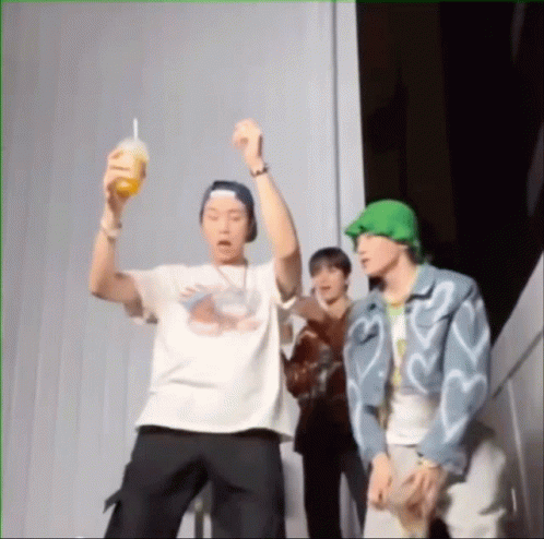 A Group Of Young Men Are Standing Next To Each Other And One Is Holding A Drink In His Hand . GIF