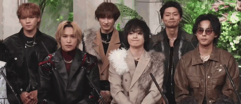 A Group Of Young Men Are Standing Next To Each Other In A Line . GIF