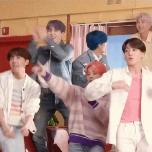 A Group Of Young Men Are Standing Next To Each Other In A Room And Dancing . GIF