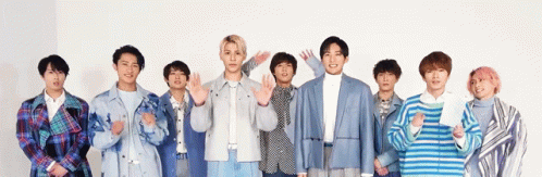 A Group Of Young Men Are Standing Next To Each Other In A Row . GIF
