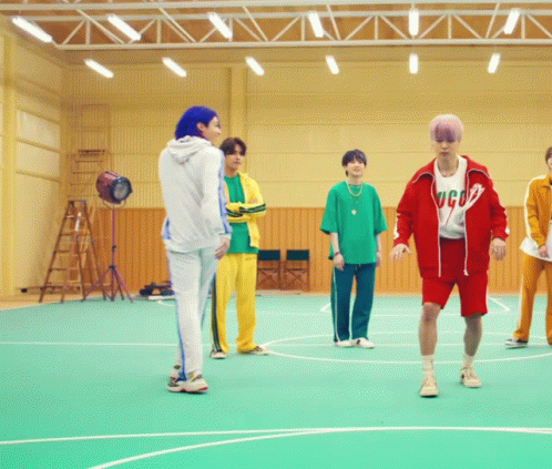 A Group Of Young Men Are Standing On A Basketball Court And One Of Them Is Wearing A Shirt That Says Gucci GIF