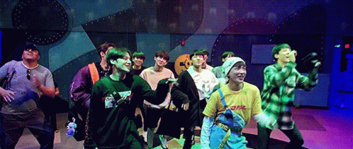 A Group Of Young Men Are Standing On A Stage Dancing . GIF