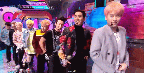 A Group Of Young Men Are Standing On A Stage With A Sign That Says Super Cup GIF