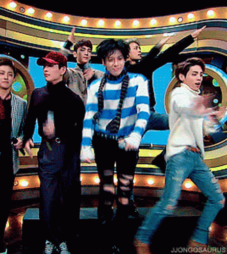 A Group Of Young Men Are Standing On A Stage With The Word Jongosaurus On The Bottom Right GIF