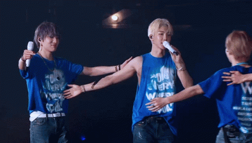 A Group Of Young Men Hugging Each Other Wearing Blue Shirts With The Letter W On Them GIF