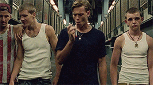 A Group Of Young Men In Tank Tops Are Standing In A Hallway GIF