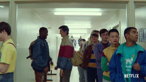 A Group Of Young Men Standing In A Hallway With A Netflix Logo On The Bottom GIF