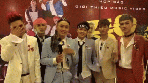 A Group Of Young Men Standing In Front Of A Sign That Says Hop Bao Giới Thiệu Music Video GIF