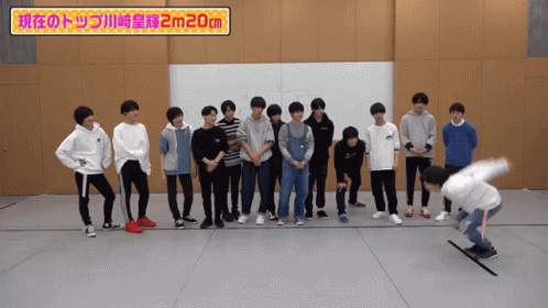 A Group Of Young Men Standing Next To Each Other With A Sign That Says 2M20cm GIF
