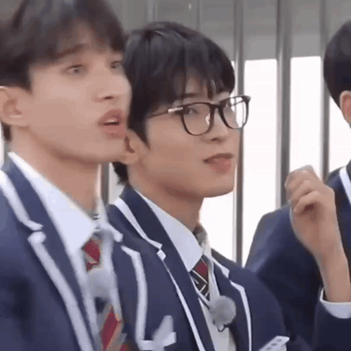 A Group Of Young Men Wearing Suits And Ties Are Standing Next To Each Other . GIF