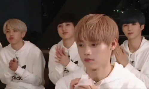 a group of young men wearing white adidas sweatshirts are clapping their hands together