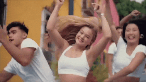 A Group Of Young People Are Dancing Together In Front Of A Yellow Building . GIF