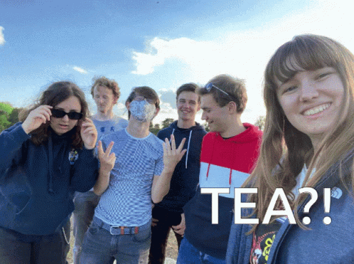 A Group Of Young People Are Posing For A Picture And One Of Them Is Wearing A Mask With The Word Tea On It GIF