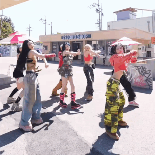 A Group Of Young Women Are Dancing In Front Of A Record Shop GIF
