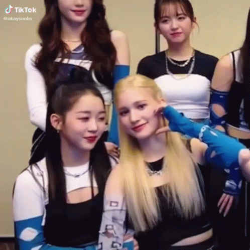 A Group Of Young Women Are Posing For A Picture Together . One Of The Girls Is Touching Another Girl 'S Face . GIF