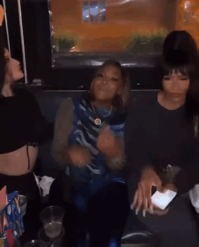 A Group Of Young Women Are Sitting Next To Each Other In A Room . GIF