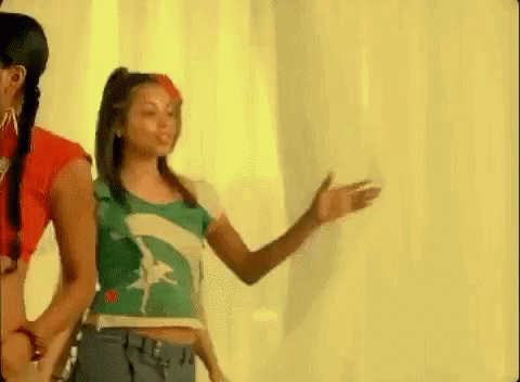 A Group Of Young Women Are Standing Next To Each Other In Front Of A White Wall . GIF