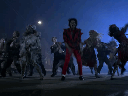 A Group Of Zombies Are Dancing On The Street In The Dark GIF