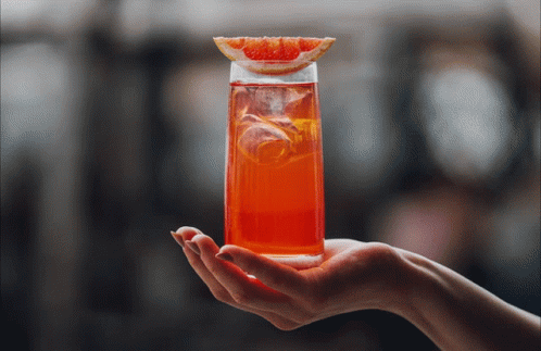 Hand Holding Tall Glass Of Orange Juice GIF