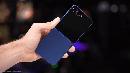 A Hand Is Holding A Blue Cell Phone With A Black Back GIF