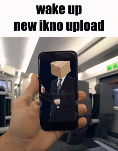A Hand Is Holding A Cell Phone With A Man In A Suit And Tie With A Box On His Head GIF