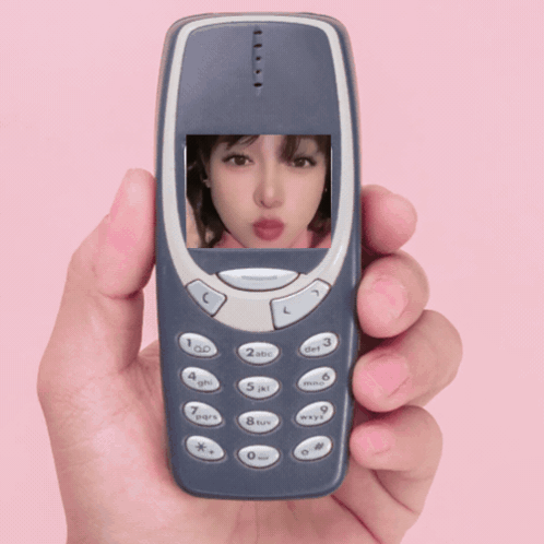 A Hand Is Holding A Cell Phone With A Picture Of A Girl On The Screen GIF