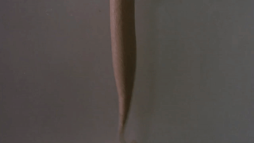A Hand Is Holding A Cup Of Ice Cream With A Dispenser Attached To It GIF