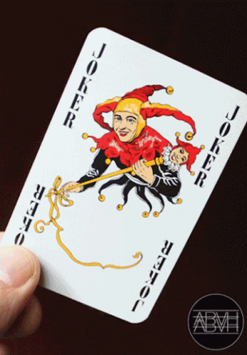 A Hand Is Holding A Joker Card With A Jester On It GIF