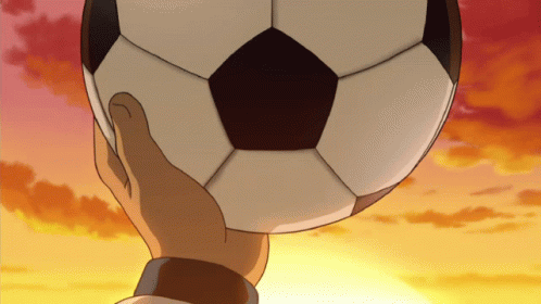 A Hand Is Holding A Soccer Ball In Front Of A Sunset Sky GIF