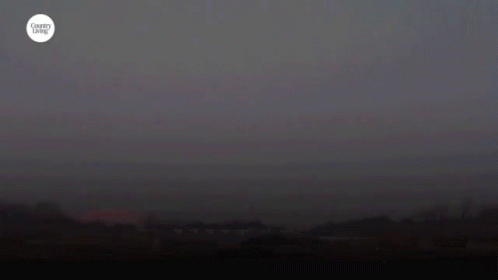 A Harvest Moon Is Shown In A Dark Sky GIF