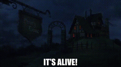 A Haunted House Is Lit Up At Night With The Words `` It 'S Alive '' Written In White Letters . GIF