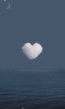 A Heart In The Middle Of A Fireworks Display Over The Ocean . GIF