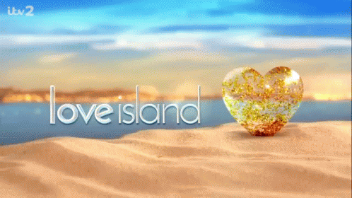 A Heart Shaped Object On A Sandy Beach With The Words Love Island In The Background GIF