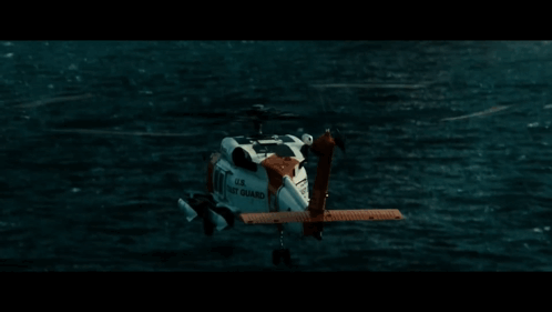 A Helicopter From The U.s. Navy Is Flying Over A Body Of Water GIF