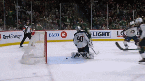 A Hockey Game Is Being Played In Front Of A Bmo Light Sign GIF