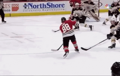 A Hockey Game Is Being Played In Front Of A Northshore University Health System Sign GIF