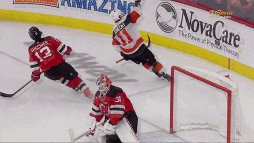 A Hockey Game Is Being Played In Front Of A Novacare Banner GIF