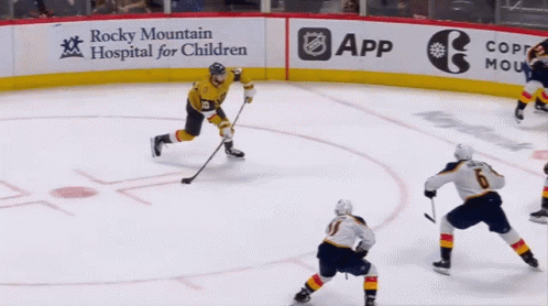 A Hockey Game Is Being Played In Front Of A Sign For Rocky Mountain Hospital For Children GIF