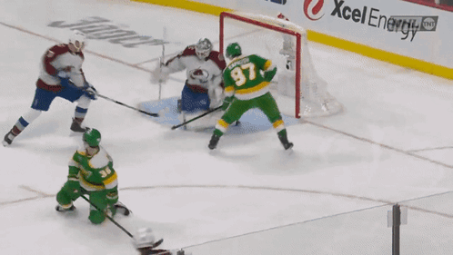 A Hockey Game Is Being Played In Front Of A Xcel Energy Sign GIF