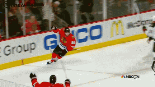 A Hockey Game Is Being Played In Front Of An Ad For Geico GIF