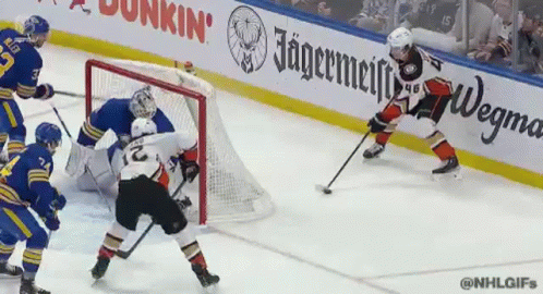 A Hockey Game Is Being Played In Front Of An Ad For Jagermeiffe GIF