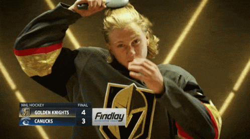 A Hockey Player Brushing His Hair In Front Of A Scoreboard That Says Findlay On It GIF